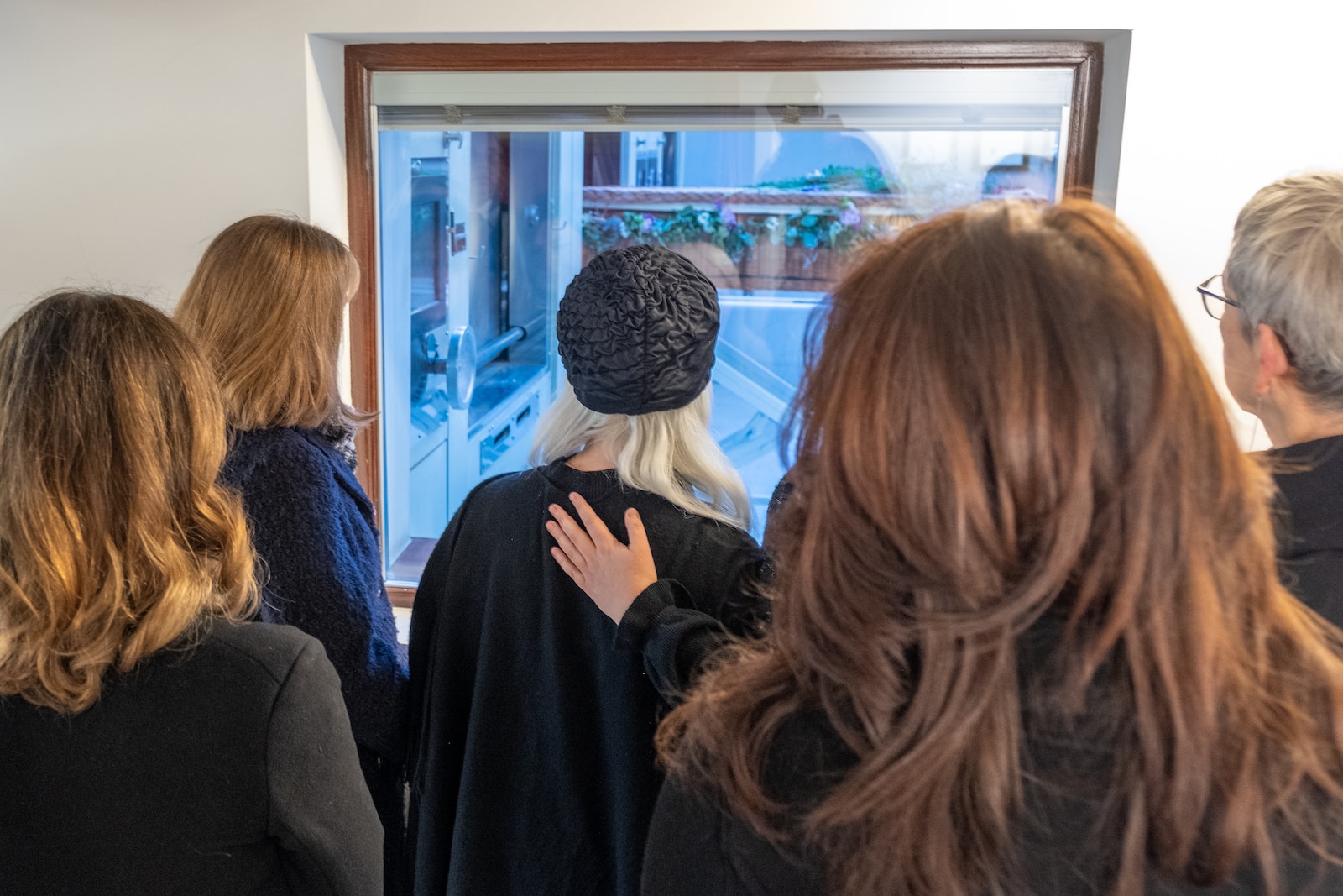 a group of people looking at a painting