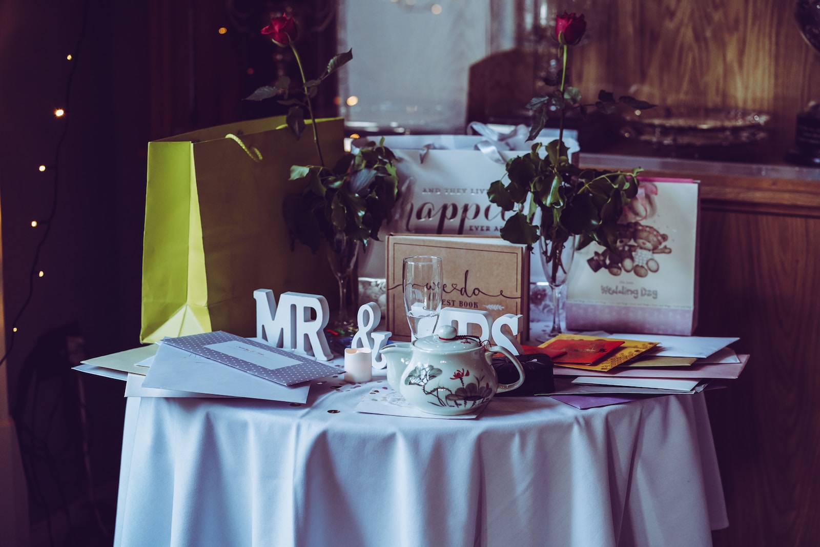 two red roses and mr. & mrs. free-standing letters on top of table